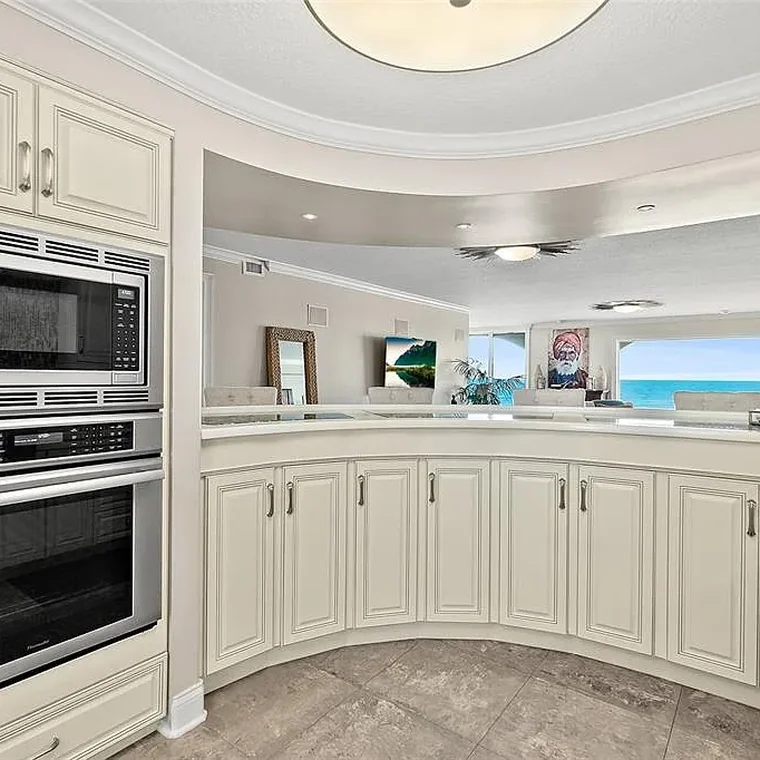 Chef's kitchen with stone countertops, solid wood cabinetry and built-in wall ovens