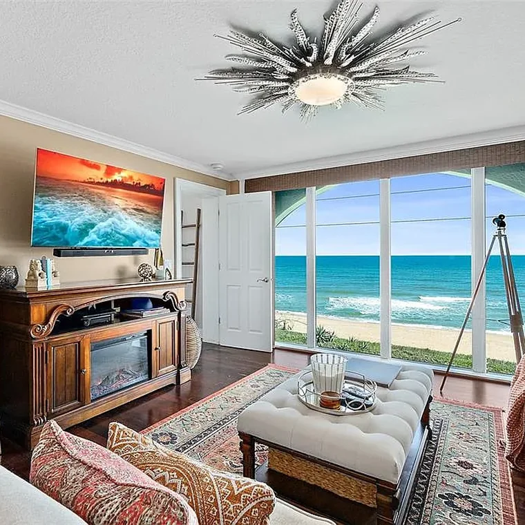 Great room with electric fireplace and sliding glass doors opening to the Atlantic Ocean view