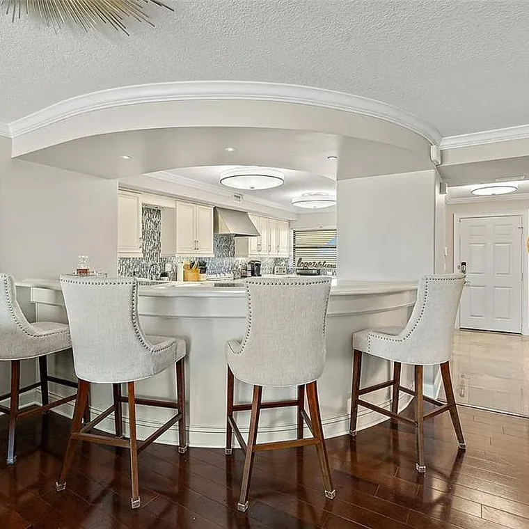 Illuminated curved sitting bar with seating for four adjoining the open-plan kitchen
