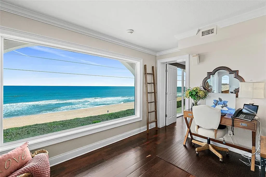 Panoramic picture window framing the Atlantic Ocean and beach from inside the oceanfront penthouse at 3390 Ocean Shore Blvd, Ormond Beach