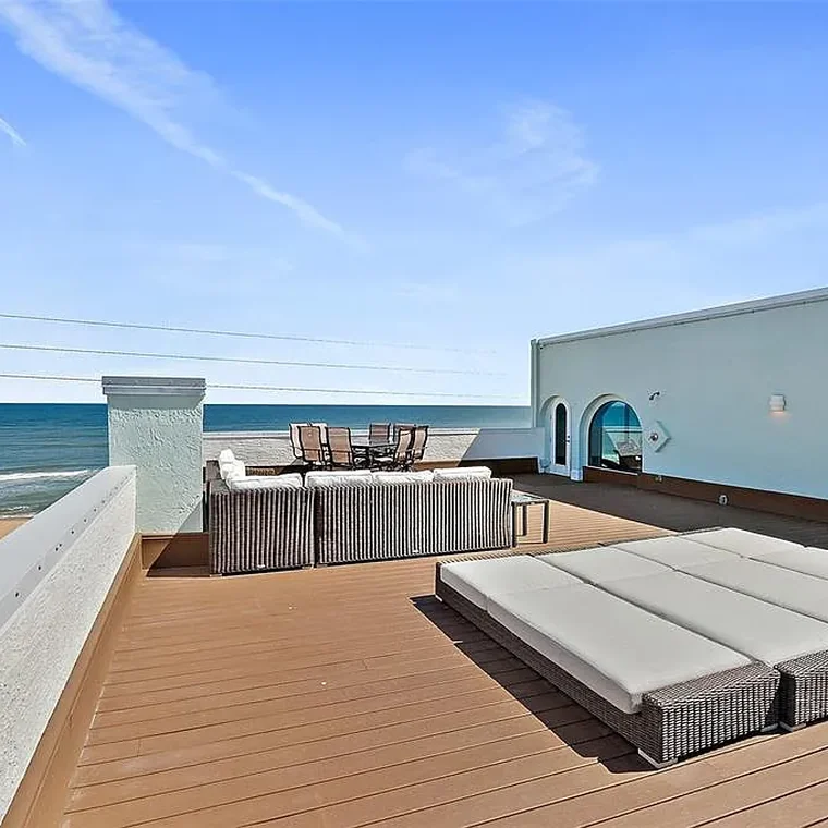 Rooftop sun deck with loungers and panoramic ocean views at the Ormond-by-the-Sea penthouse